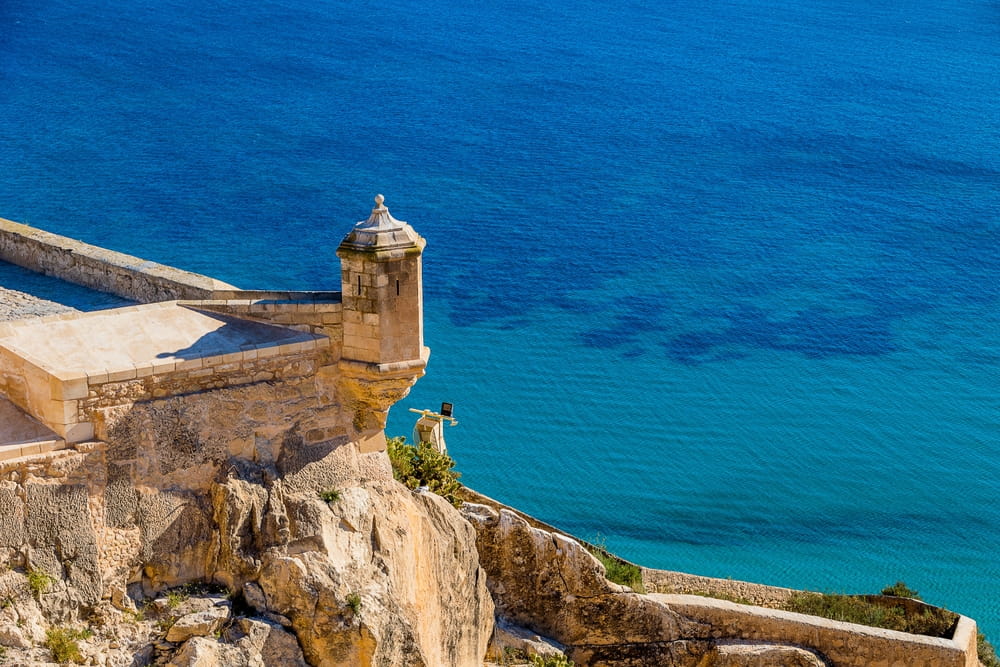 Watchtower at Santa Barbara Castle in Alicante overlooking the blue Mediterranean Sea
