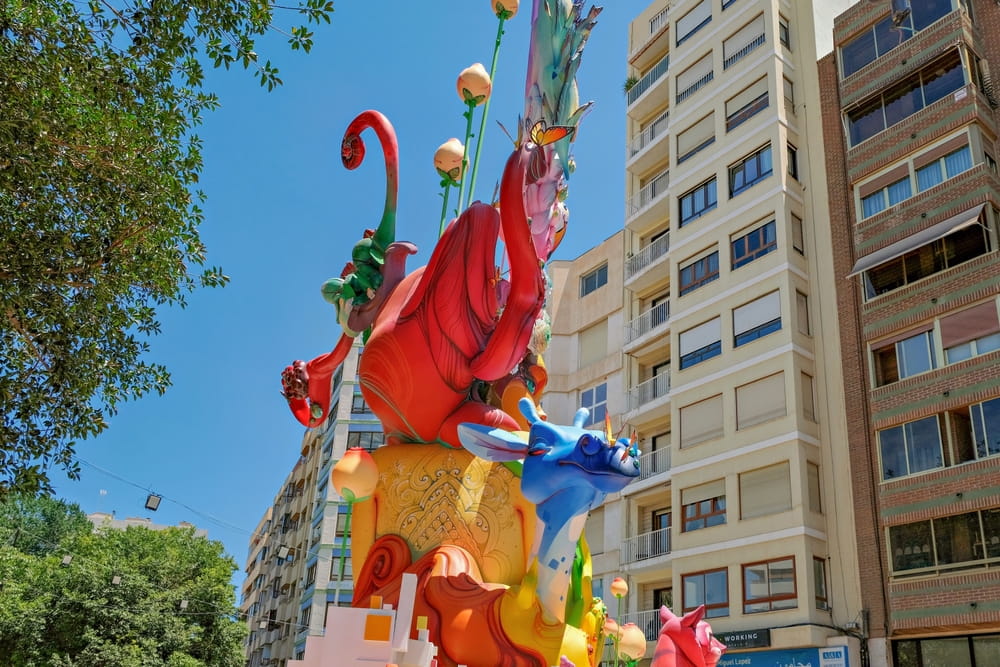 Monumento colorido de las Hogueras de San Juan en una calle de Alicante durante la fiesta